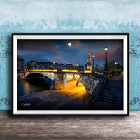 a picturesque night scene of a bridge illuminated by warm lighting, with a full moon in the sky and a tall spire in the background.