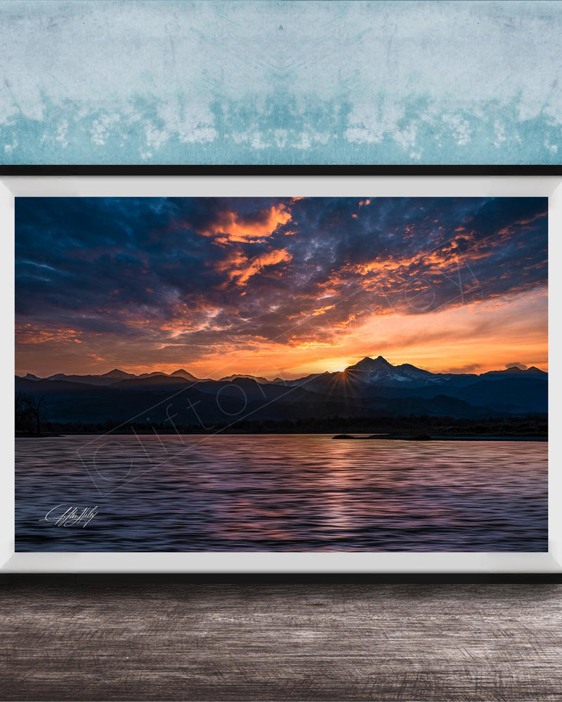 a breathtaking sunset over a mountain range, with the sun setting behind the peaks and casting a warm, golden glow across the sky.