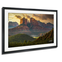 a breathtaking view of a mountainous landscape with towering red rock formations bathed in the warm glow of a setting sun.