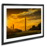 a cityscape at sunset, with the Washington Monument and other buildings silhouetted against a vibrant orange sky.
