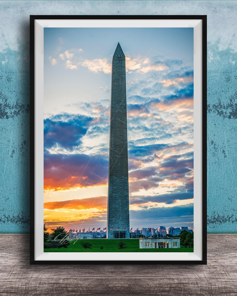 the Washington Monument, a tall obelisk, against a colorful sunset sky with clouds.