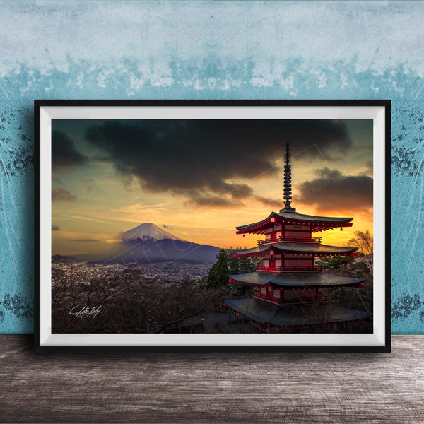 A framed photograph of the Mount Fuji, a famous landmark in Japan, with a red pagoda-style building in the foreground and a dramatic sky in the background.