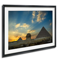the Great Pyramids of Giza against a vibrant sunset sky, with the Sphinx in the foreground.