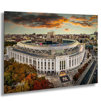 a large, circular stadium with a curved roof, surrounded by a cityscape with buildings and trees. The sky is filled with clouds, and the sun is setting, creating a dramatic and colorful backdrop.