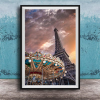 A framed photograph of the Eiffel Tower and a colorful carousel, set against a dramatic sky with clouds.