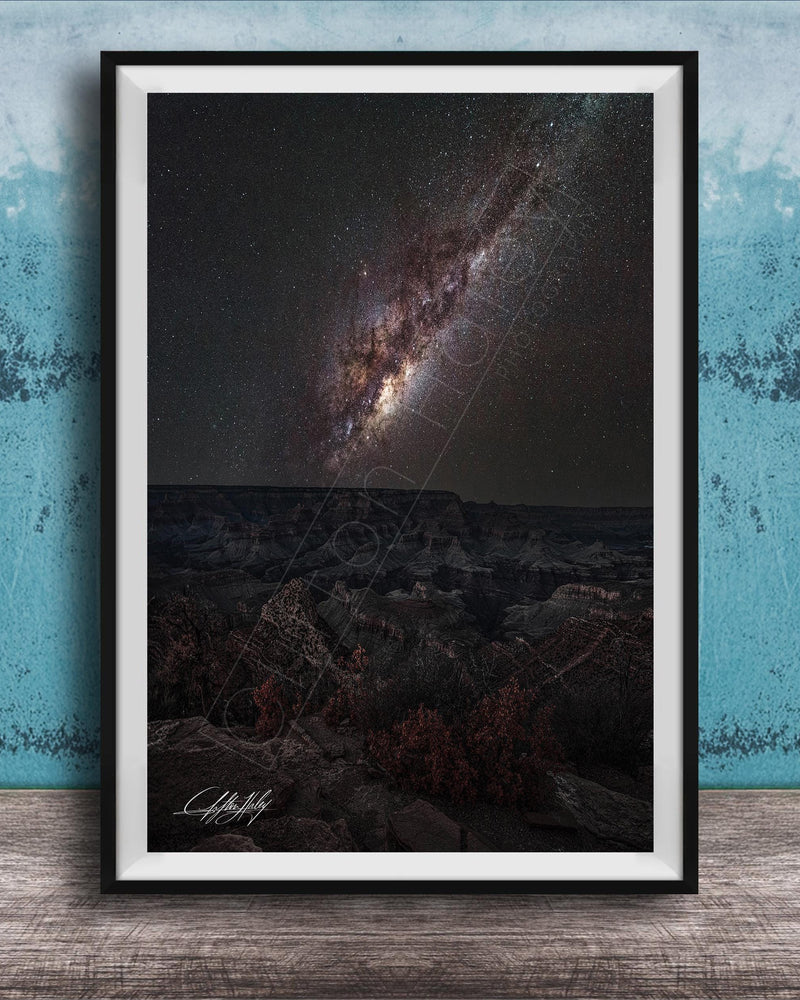 The image is a framed photograph of a night sky with a distant galaxy, set against a dark background.