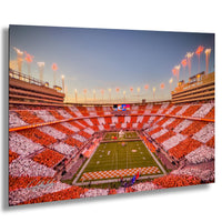 a large, brightly lit football stadium filled with spectators, with a checkered pattern of red and white on the field.