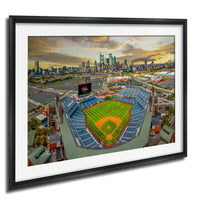 An aerial view of a baseball stadium with a city skyline in the background.