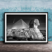 A black and white photograph of the Great Sphinx and the Pyramid of Giza against a night sky, with a small shooting star visible in the sky.