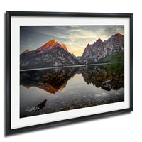 a serene mountain landscape with a calm lake reflecting the majestic peaks.