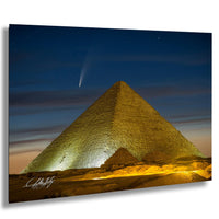 a large pyramid illuminated at night, with a bright star visible in the sky above it.