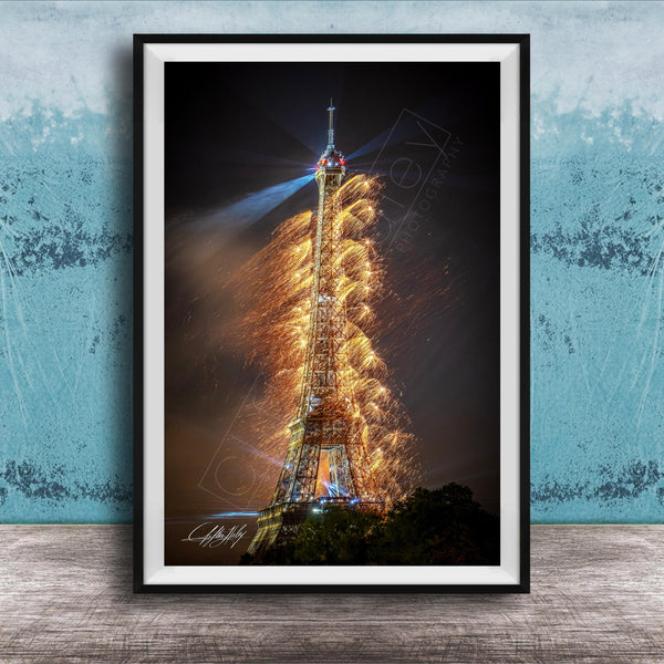 a tall, illuminated tower with a bright light at the top, surrounded by a colorful display of fireworks.