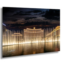 a large, illuminated building with a fountain in front of it, creating a visually striking scene at night.