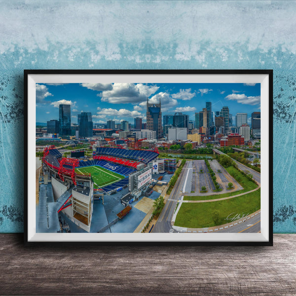 The image is an aerial view of a city skyline, featuring tall buildings and a large sports stadium with a red roof.