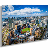 An aerial view of a large baseball stadium surrounded by a city skyline, with tall buildings and skyscrapers in the background.