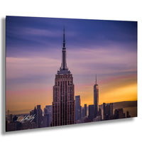 the iconic Empire State Building, a famous skyscraper in New York City, with its distinctive spire and silhouette against a vibrant sunset sky.