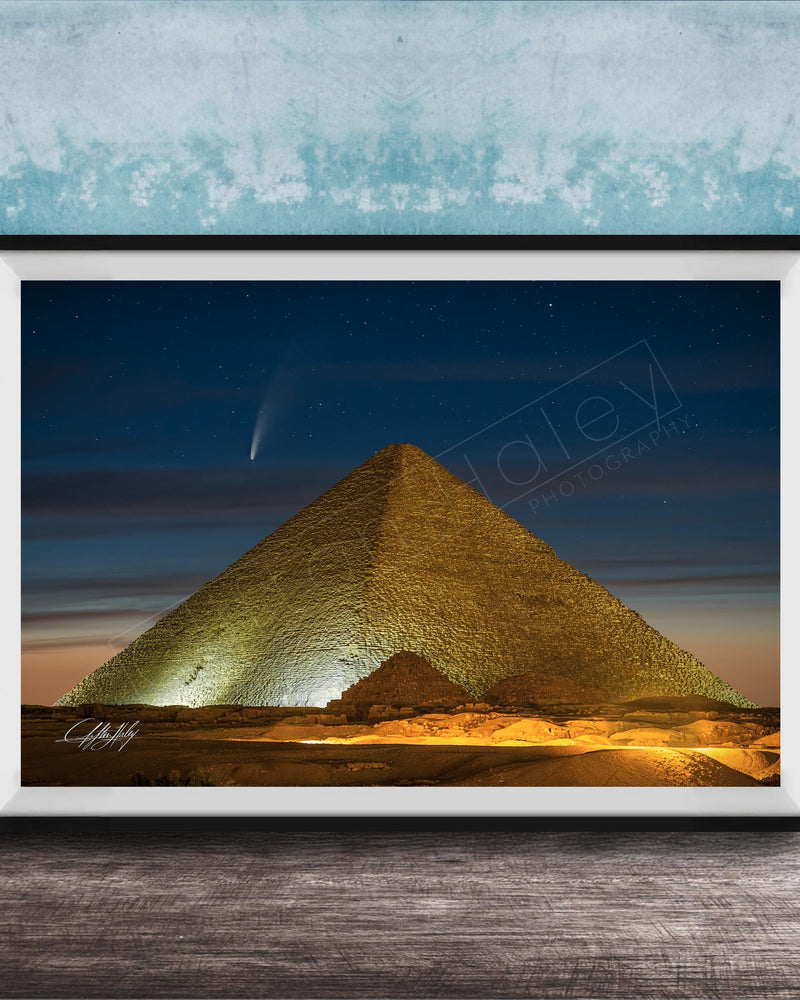 A framed photograph of the Great Pyramid of Giza at night, with a bright star visible in the sky above the pyramid.