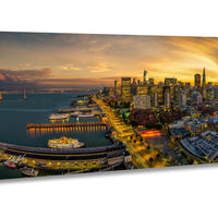 a vibrant cityscape at sunset, with a large body of water in the foreground and a skyline of tall buildings in the background. The city is illuminated by the warm glow of the setting sun, creating a picturesque and serene atmosphere.