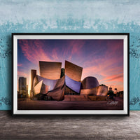 A framed photograph of the Guggenheim Museum in Bilbao, Spain, at sunset, with the distinctive curved architecture of the building illuminated against a colorful sky.