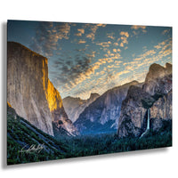 a breathtaking view of a mountainous landscape at sunset, with towering cliffs and a cascading waterfall.