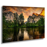 a serene landscape with a river reflecting the vibrant colors of the sky, surrounded by lush greenery and towering mountains.