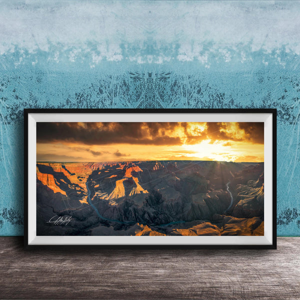 A framed photograph of a breathtaking landscape, depicting a dramatic sunset over a rugged mountain range.