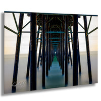 A long, wooden pier extends into the distance, with a series of dark wooden posts and beams stretching out into the water.