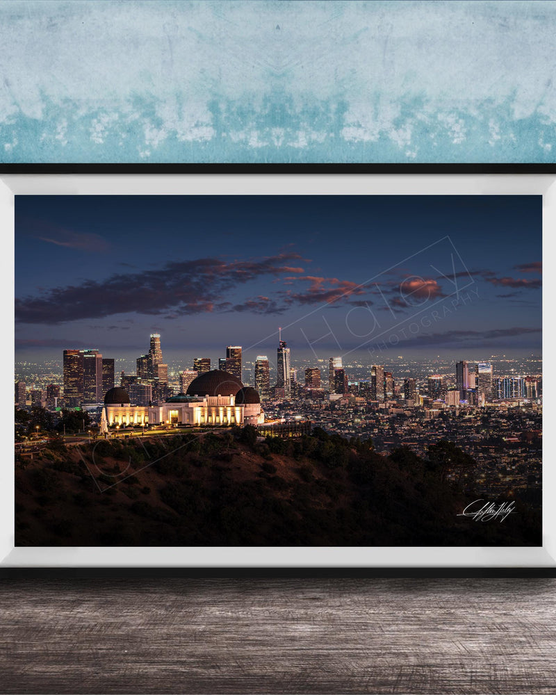 A framed photograph of the Los Angeles skyline at night, with the iconic Griffith Observatory prominently visible in the foreground.