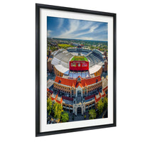 An aerial view of a large stadium with a red roof and a large sign on top.