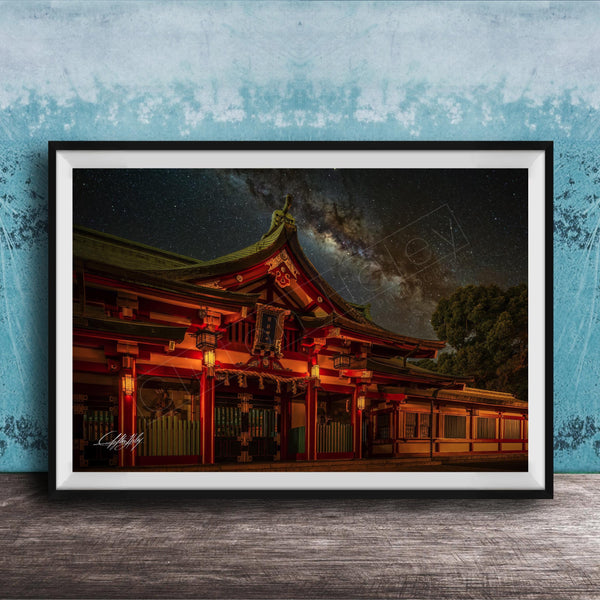 A framed photograph depicting a traditional Japanese temple at night, with a starry sky and a galaxy in the background.