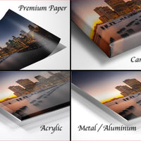 The image is a collage of four different views of a city skyline at sunset, with the cityscape appearing in various materials such as acrylic, metal, and aluminum.