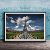 a large, framed picture of the Eiffel Tower in Paris, France, with a lush, green park in the foreground.