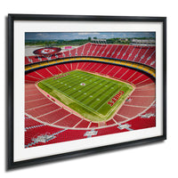a framed aerial view of a football stadium with a green field and red seating.