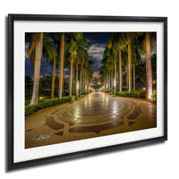 A well-lit, circular walkway lined with palm trees at night, creating a serene and inviting atmosphere.