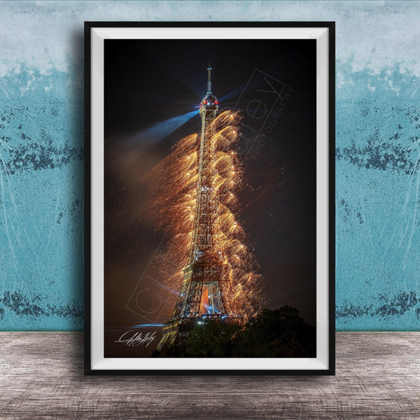 a tall, illuminated tower with a fireworks display lighting up the night sky.