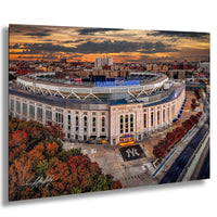 a large, circular stadium with a distinctive New York Yankees logo, surrounded by a cityscape and a colorful sunset sky.
