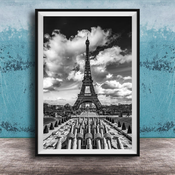 A black and white photograph of the Eiffel Tower in Paris, France, with a cloudy sky in the background.