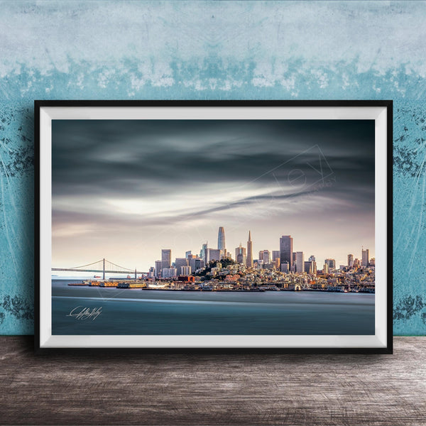 A framed photograph of the San Francisco skyline at sunset, with the Golden Gate Bridge and other iconic structures visible in the distance.