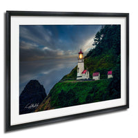 A framed photograph depicting a lighthouse on a cliff, with a dramatic sky and clouds in the background.